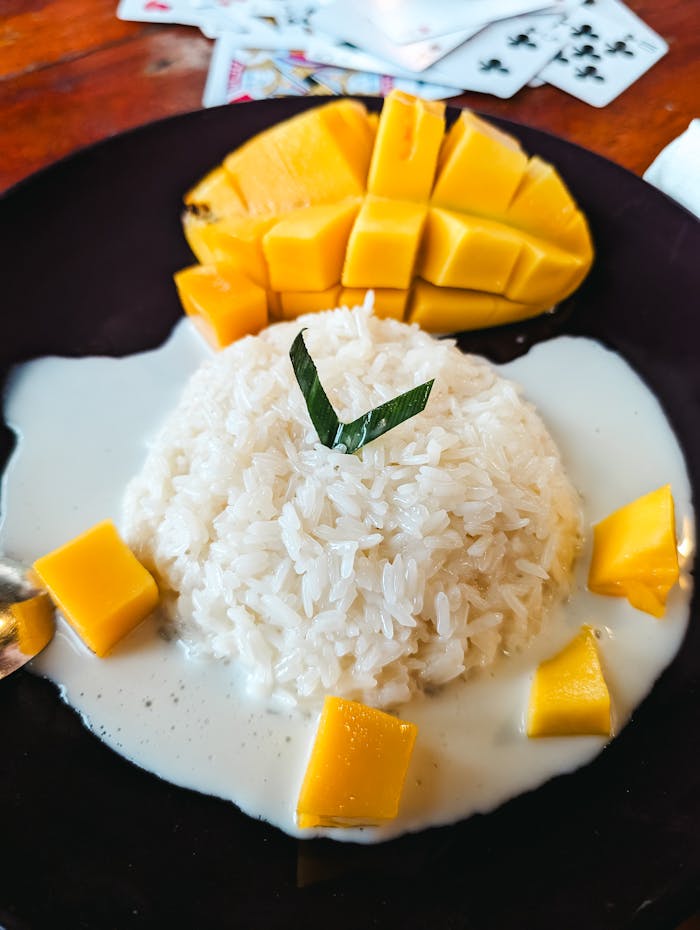 A plate of rice with mango and mango slices